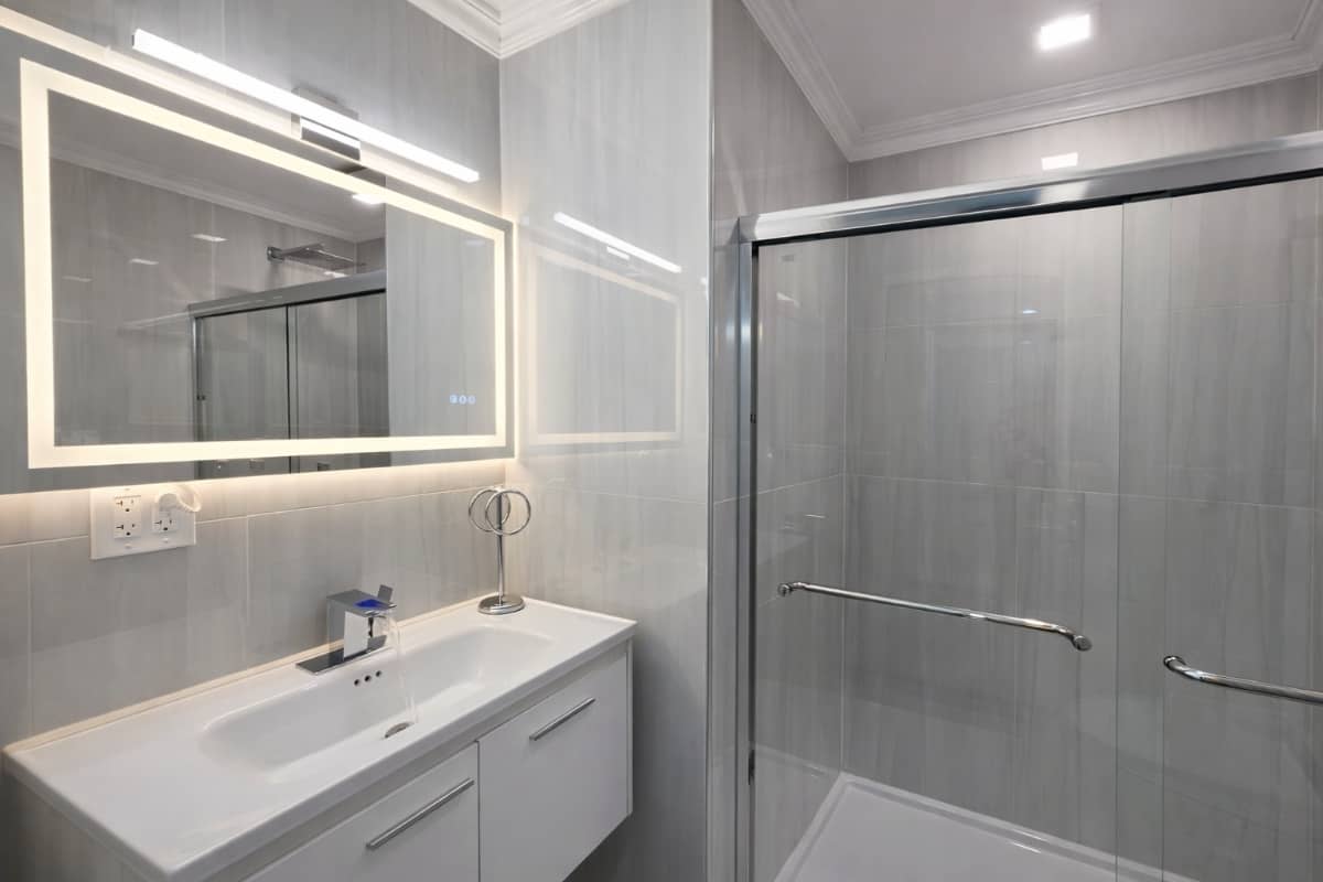 luxurious bathroom remodel with clear shower door and light up mirror